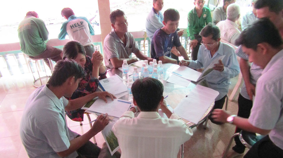 Local farmers fill the daily farm records during the Sustainable Rice Platform (SRP) class. (Photo credit: GIZ Vietnam)